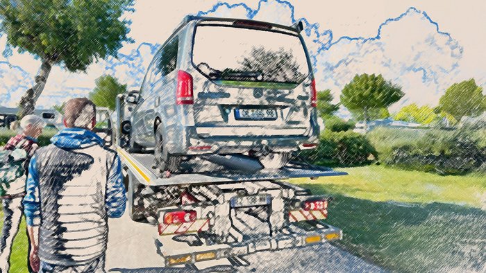 : Ein Campingbus ist auf einen Abschlepper aufgeladen.