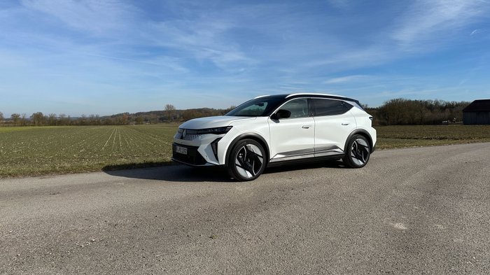 Renault Scenic E-Tech 220 parkt vor einem Feld. 