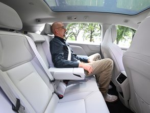 Ein Mann sitzt auf der Rückbank des Volvo EX60. 