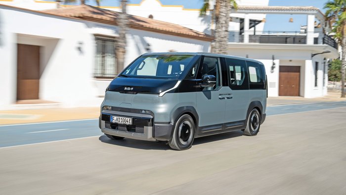 Kia PV5 fährt auf einer Straße. 