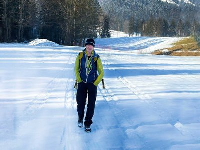 Wanderer im Schnee vor Landschaftskulisse.