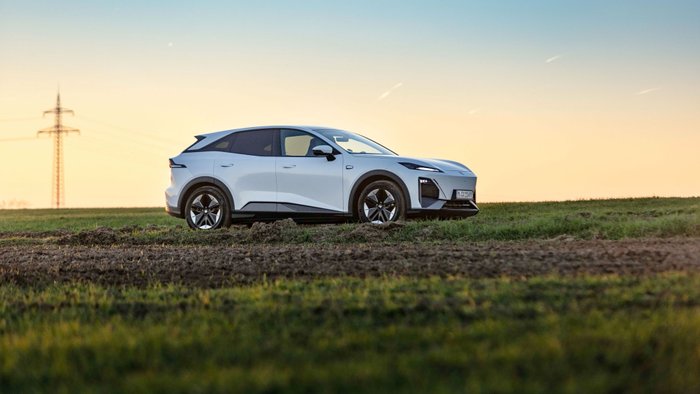Ein weißer Changan Deepal S07 parkt auf einer Wiese.