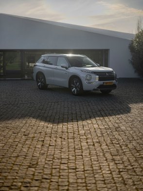 Mitsubishi Outlander mit 20-Zoll-Felgen parkt in der Abendsonne.