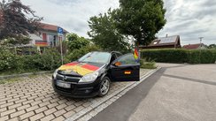 Ein Auto geschmückt mit Deutschland-Fahnen und Spiegelüberziehern.