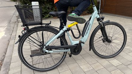 Eine Radfahrerin mit einem Krytonite Bügelschloss am Fahrradrahmen befestigt. 
