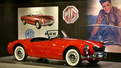 Roter Blue Hawaii MG in Ausstellung vor einem Foto mit Elvis.