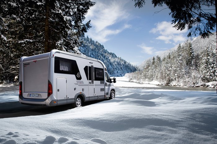 Ein Wohnmobil steht in einer Winterlandschaft.