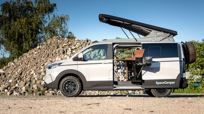 SpaceCamper Classic+ parkt mit geöffnetem Dach und offener Schiebetür.