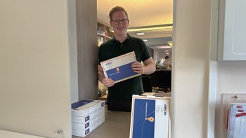 Mann bringt ein ARCD-Urlaubspaket zur ARCD-Poststelle