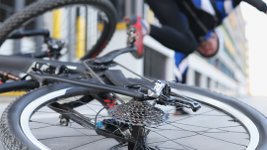 Ein Radfahrer ist gestürzt und liegt auf dem Boden. 