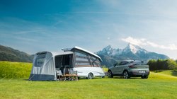 Easy Caravanning TakeOff steht aufgeklappt auf einem Campingplatz mit E-Auto als Zugfahrzeug.