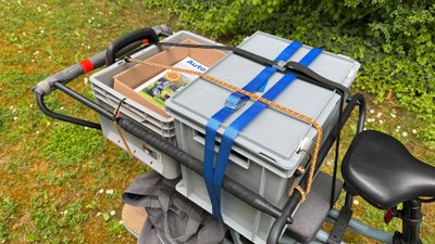 Zwei Kisten mit Spanngurten auf einem Lastenrad.