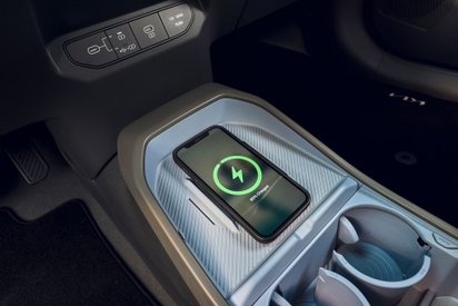 Smartphone lädt auf einer Ladefläche im Kia EV3.