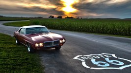 Classic Car am Rand einer Straße mit Route-66-Symbol auf dem Asphalt.