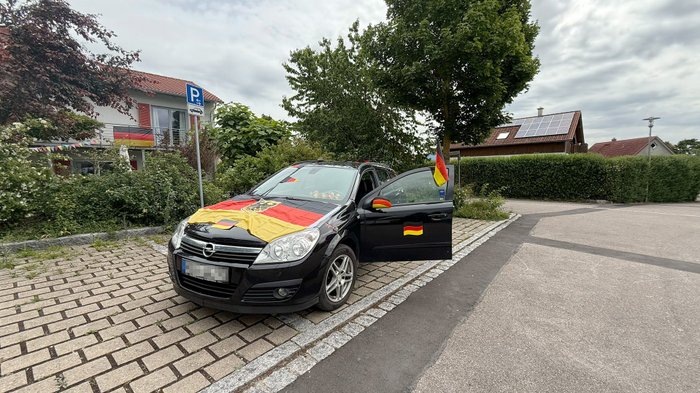Ein Auto geschmückt mit Deutschland-Fahnen und Spiegelüberziehern.