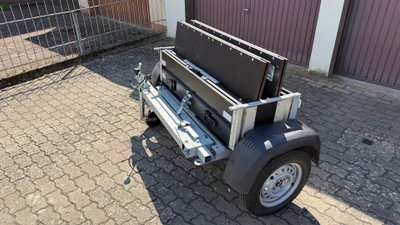 Zusammengefalteter Faltos-Anhänger steht in einer Einfahrt. 
