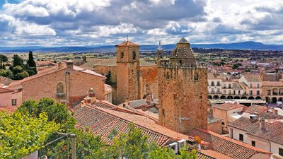 Historische spanische Altstadt mit Türmen und Landschaft im Hintergrund.