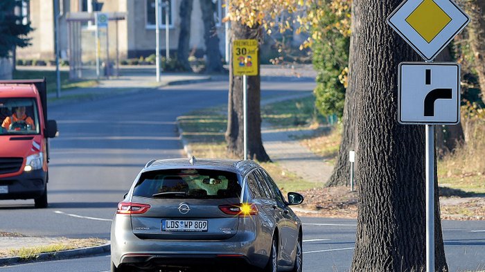 Ein Auto fährt auf einer Straße mit abknickender Vorfahrt.