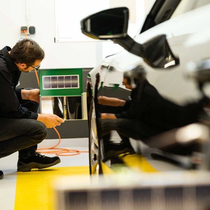 Ein Techniker kalibiert die Kamera hinter einer Windschutzscheibe.