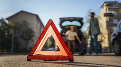 Ein Warndreieck ist vor einem verunfallten Auto aufgestellt. 