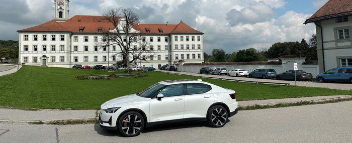 Ein weißer Polestar 2 parkt vor einem Schloss.