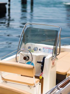 Kleines offenes Motorboot liegt an der Reeling.