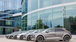 Hyundai Autos in einer Reihe vor einem Gebäude mit Glas-Verkleidung.