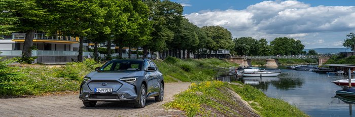 Ein Subaru Solterra parkt an einer Uferstraße.