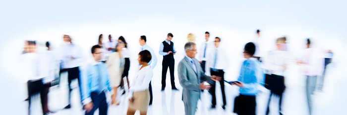 Unscharfe Aufnahme einer Menschengruppe in weißer Umgebung.