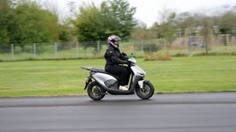 Eine Frau fährt den Elektroroller Honda CUV e