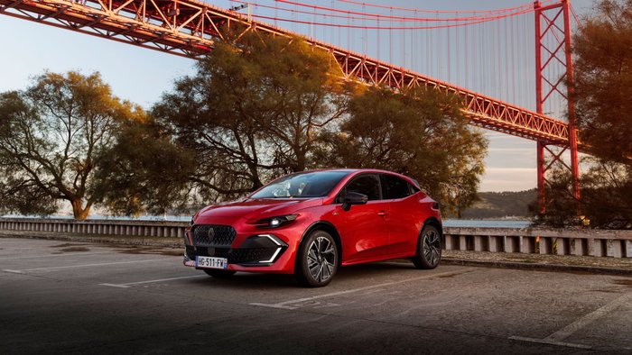 Roter Renault Clio mit Brücke im Hintergrund 