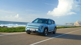 Blauer Kia EV3 fährt auf einer Straße
