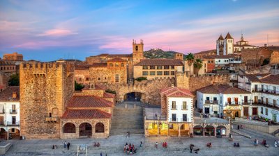 Spanische Altstadt mit mittelalterlichen Häusern und Türmen in der Abenddämmerung.