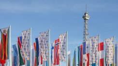 Nationalflaggen verschiedener Länder und Flaggen mit ITB-Logo wehen vor dem Berliner Messeturm im Wind.