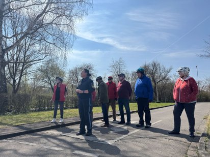 Eine Gruppe Senioren übt zu Fuß das Linksabbiegen. 