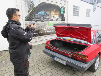 Dekra-Prüfer Markus Becker fotografiert geöffneten Kofferraum des Honda Prelude Coupé.