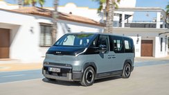 Kia PV5 fährt auf einer Straße. 