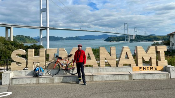 Prof. Jürgen Wrede mit Fahrrad vor der Kurushima Kaikyō Bridge in Japan