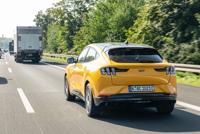 Ein gelbes Auto auf einer viel befahrenen Straße.