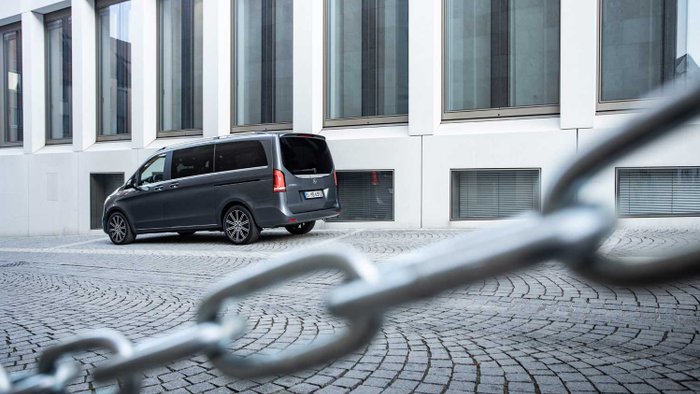 Ein Mercedes-Van steht auf einem Hof hinter einer Absperrkette.