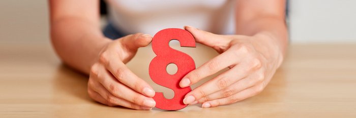 Hand hält Paragraph Zeichen in der Hand.