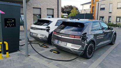 Zwei Hyundai Autos, welche an einer Ladesäule angeschlossen sind.