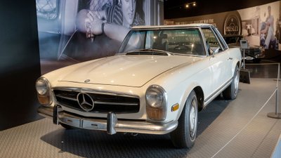 Weißer Mercedes 280 SL Pagode in Ausstellung vor einem Foto mit Elvis.