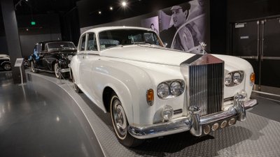 Weißer Rolls-Royce Silver Cloud III in Ausstellung vor einem Foto mit Elvis.