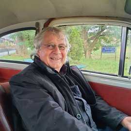 lachender Mann im Oldtimer.