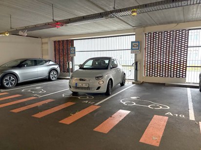 Fiat 500e lädt an einer Ladesäule im Parkhaus in Dunkerque.