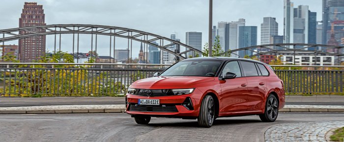 Ein roter Opel Astra Sports Tourer Electric fährt durch die Stadt.