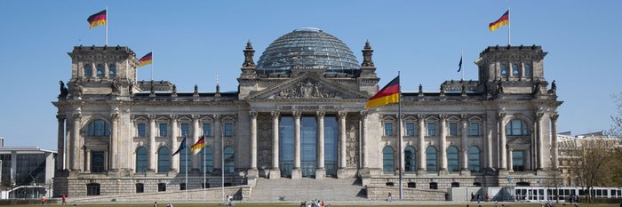 Das Gebäude des Bundestages in Berlin bei blauem Himmel.