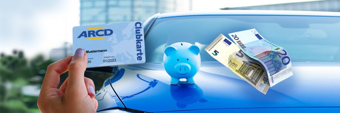 Blaues Sparschwein steht auf Motorhaube eines blauen Autos. Hand mit ARCD-Clubkarte und Geldscheine.