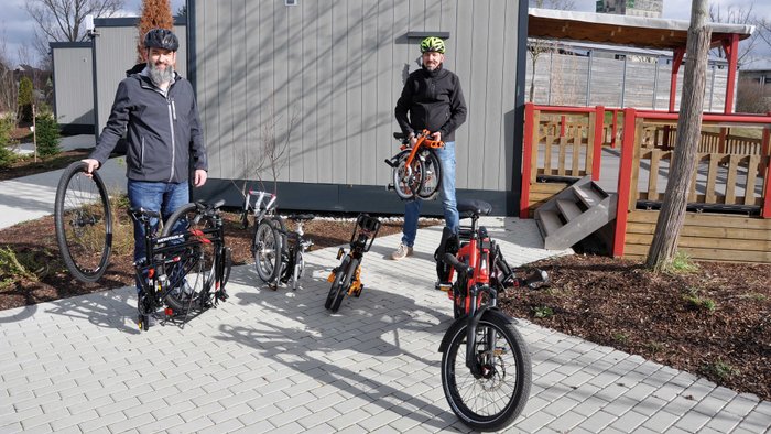 Thomas Schreiner (l.) und  Wolfgang Sievernich präsentieren fünf der sechs Test-Falträder an den Mobile Homes des Phoenix-Reisemobilhafens in Bad Windsheim. 